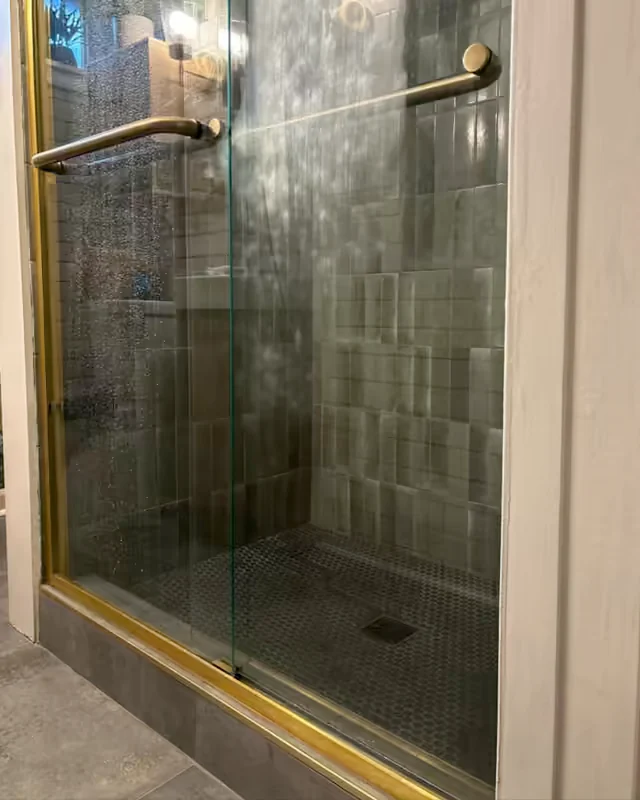 Before: a glass shower door covered in water spots and soap haze.