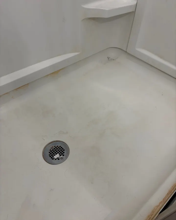 Before: a shower floor with yellow staining around the edges.