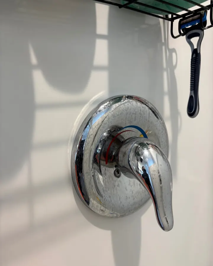Before: a chrome shower handle dulled by water spots.