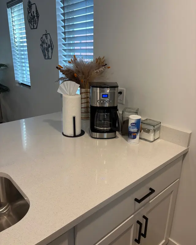 A clean kitchen counter with a coffee maker and paper towels set out.